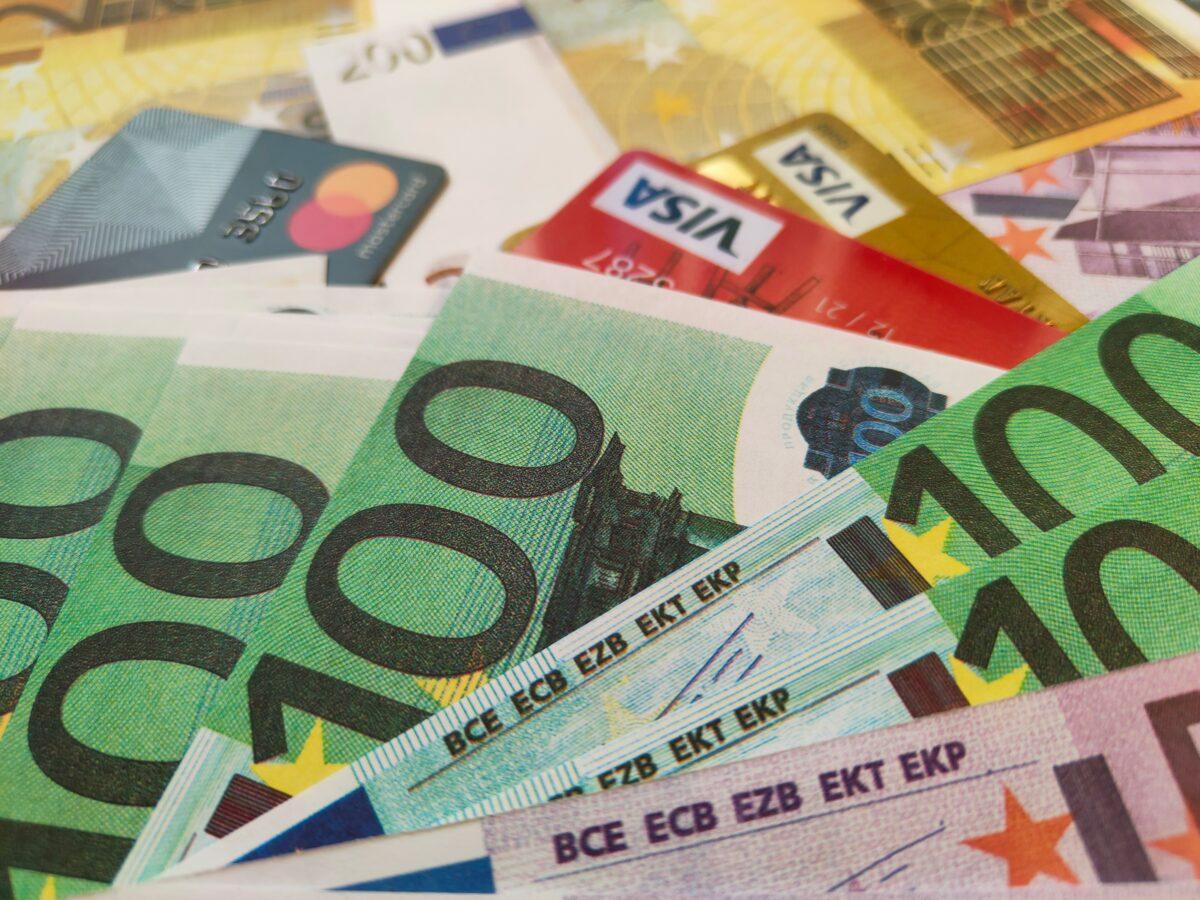 Liasse de billets en euros entourée de diverses cartes de crédit de différentes couleurs, symbolisant Compte bancaire fermé ou refus d'ouverture